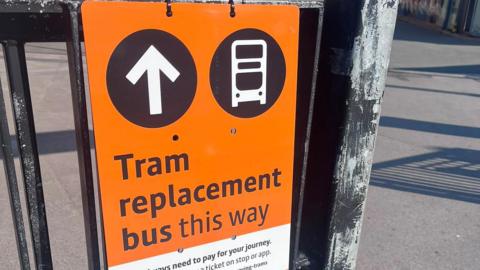 An orange sign for a tram replacement bus