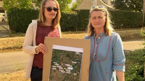 Helen and Charlotte stood holding test locations on a map.