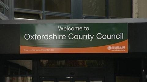 The Oxfordshire Council sign hanging over the entrance to its headquarters.