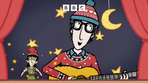 Nick Cope in a winter bobble hat playing a guitar on stage with the moon, stars and an elf in the background.