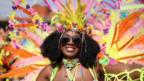 A woman in a head dress of colourful feathers 