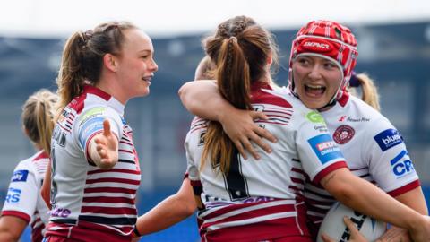WIgan's Ellise Derbyshire is congratulated by Mary Coleman and Isabel Rowe on her second try against York.