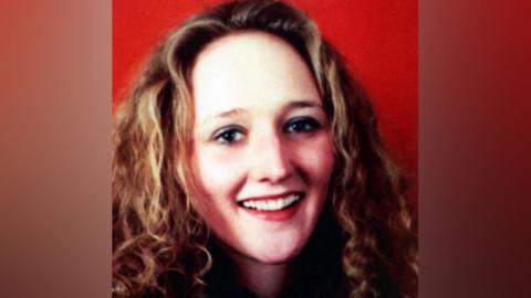Close up of Janet Murgatroyd. She is smiling and has long fair curly hair