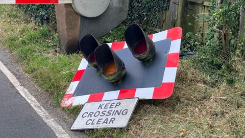 A set of railway crossing lights on the ground after being knocked off 