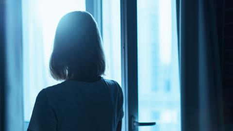 Woman silhouette in front of the window