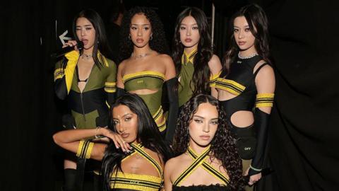 Six-member girl group Katseye in black, yellow and green outfits at the Grammy Awards.