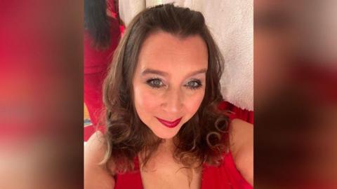 A selfie of Harriet Annabelle who is in a red top and has red lipstick on