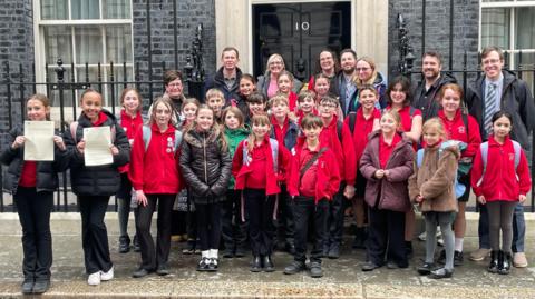 Schoolchildren and teachers outside 10 Downing Street