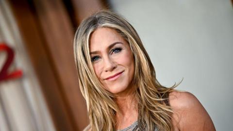 Image shows Jennifer Aniston looking at the camera on the red carpet 