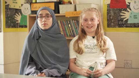two school girls looking at camera smiling