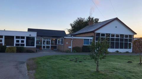 A school building, pictured at sunset.