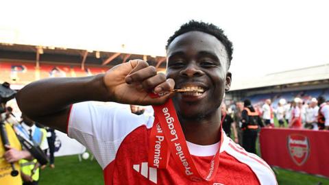saka biting his medal