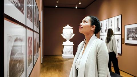 A woman looking at a drawing in an art gallery.