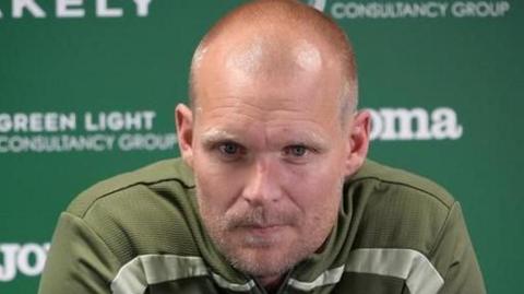 Liam Manning pictured speaking to the media