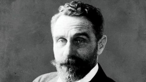 An archive image of Roger Casement in Black and white. He has a thick beard and moustache, and short wavy hair. 