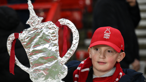 A Nottingham Forest fan holds a tin foil FA Cup 