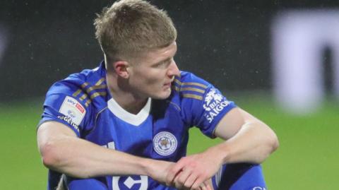 Jordan James sits on the pitch at Wrexham before being substituted