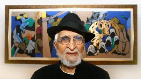 Leading Indian artist M.F Husain poses in front of one of his paintings in Raan bar at the O2 Arena on July 3, 2007 in London, England. Raan a new indian restaurant set up at the O2 Arena boasts three of Husain's latest paintings. Now in his 80s Husain continues to paint prolifically and his paintings have sold for millions. This particular painting depicts Mother Theresa showing her taking care of children. (Photo by Chris Jackson/Getty Images)
