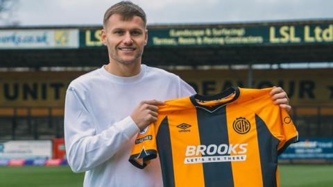Elliott Nevitt pictured holding a Cambridge shirt