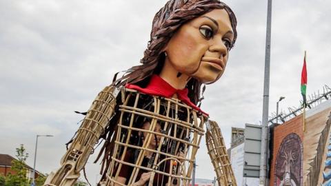 Little Amal, the puppet of a Syrian refugee child, pictured on the Falls Road during a tour of Belfast