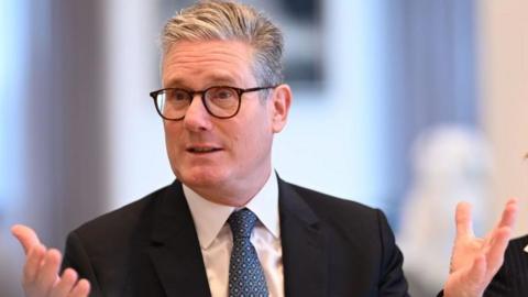 Prime Minister Keir Starmer sat at a breakfast meeting in New York looking animated and wearing a suit