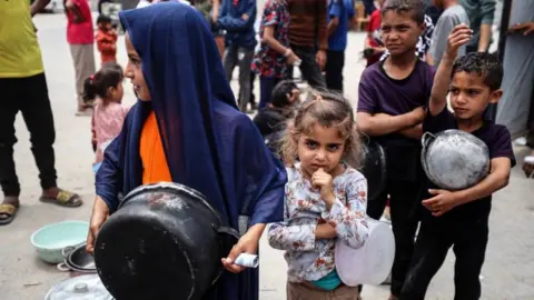 Children queue for food in Gaza.