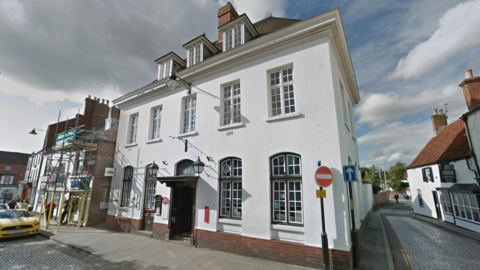 The front of the Post Office branch in Horncastle Market Place. A white building with a black door and has three attic windows with white window frames.