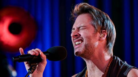 Chesney Hawkes singing into a microphone