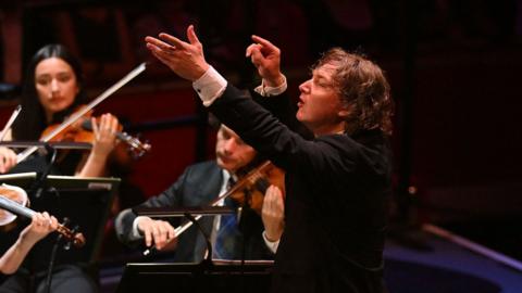 A conductor conducting an orchestra