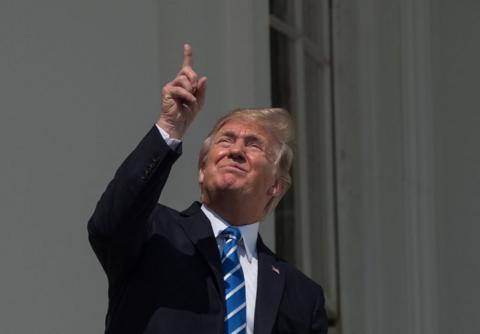 President Trump looks up at the partial solar eclipse from the balcony of the White House in Washington DC on 21 August 2017