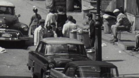 Pedestrians and cars travel on a New York street