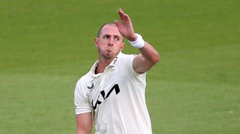 Dan Worrall, with a new shaved haircut, bowling for Surrey