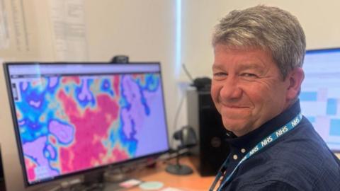 Dr David Bailey in front of computer screen