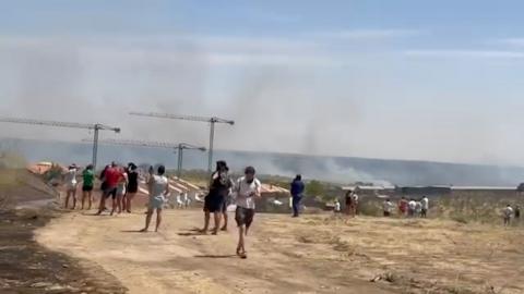 People stand on a sandy hillside