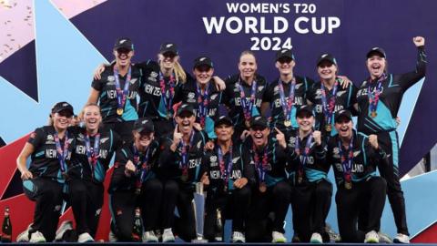 New Zealand's players pose with the T20 World Cup trophy in 2024