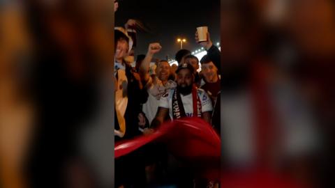A group of Aston Villa fans celebrating in the street