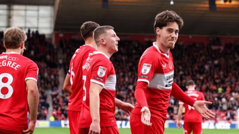 Hayden Hackney gestures with his arms outstretched and a smile on his face after Middlesbrough score against Birmingham, with three team-mates behind him
