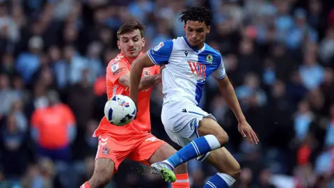 Liam Kitching of Coventry City challenges Kristi Montgomery of Blackburn Rovers 