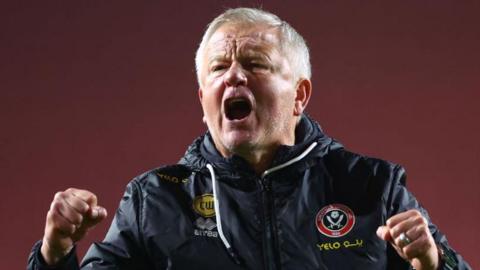 Sheffield United head coach Chris Wilder clenching his fists with his mouth open in celebration.