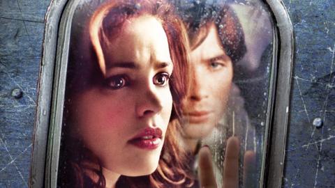 The image shows a plane window from the outside, Rachel McAdams looks out with a fearful expression on her face and an open palm on the window. Cillian Murphy can be seen behind her. 