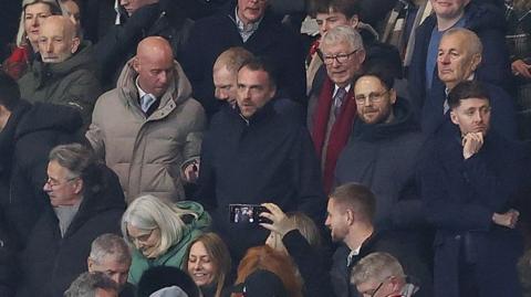 Nicky Butt (grey coat) and Paul Scholes to his left sat with former manager Sir Alex Ferguson (red scarf) at Manchester United's FA Cup defeat by Brighton