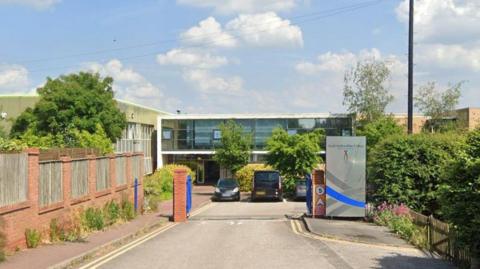 The entrance of a car park with a silver totem to the right hand side with the South Staffordshire College logo at the top