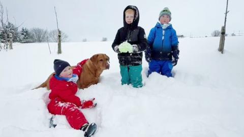 kids in snow with dog