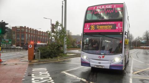 A number 35 double decker bus leaves Leeds Bus Station on a gloomy day.