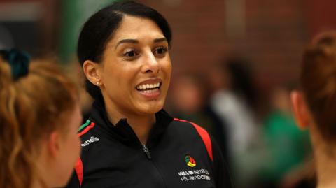 Sara Moore smiles as she speaks to players