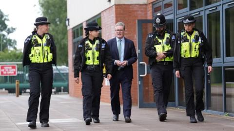 Prime Minister Sir Keir Starmer walks with police officers