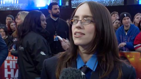 Billie Eilish has shoulder length brown hair and oval glasses on the red carpet
