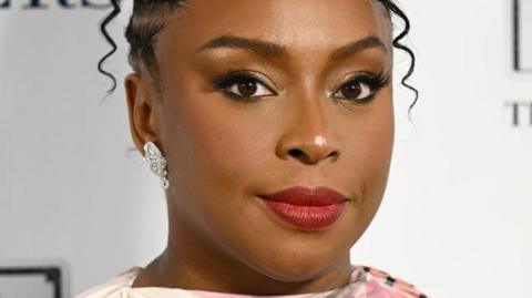 Nigerian author Chimamanda Adichie wearing a red lipstick in an event function