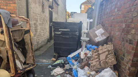 Overflowing bins outside a house