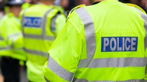 A police stock image shows high vis jackets which read "POLICE".
